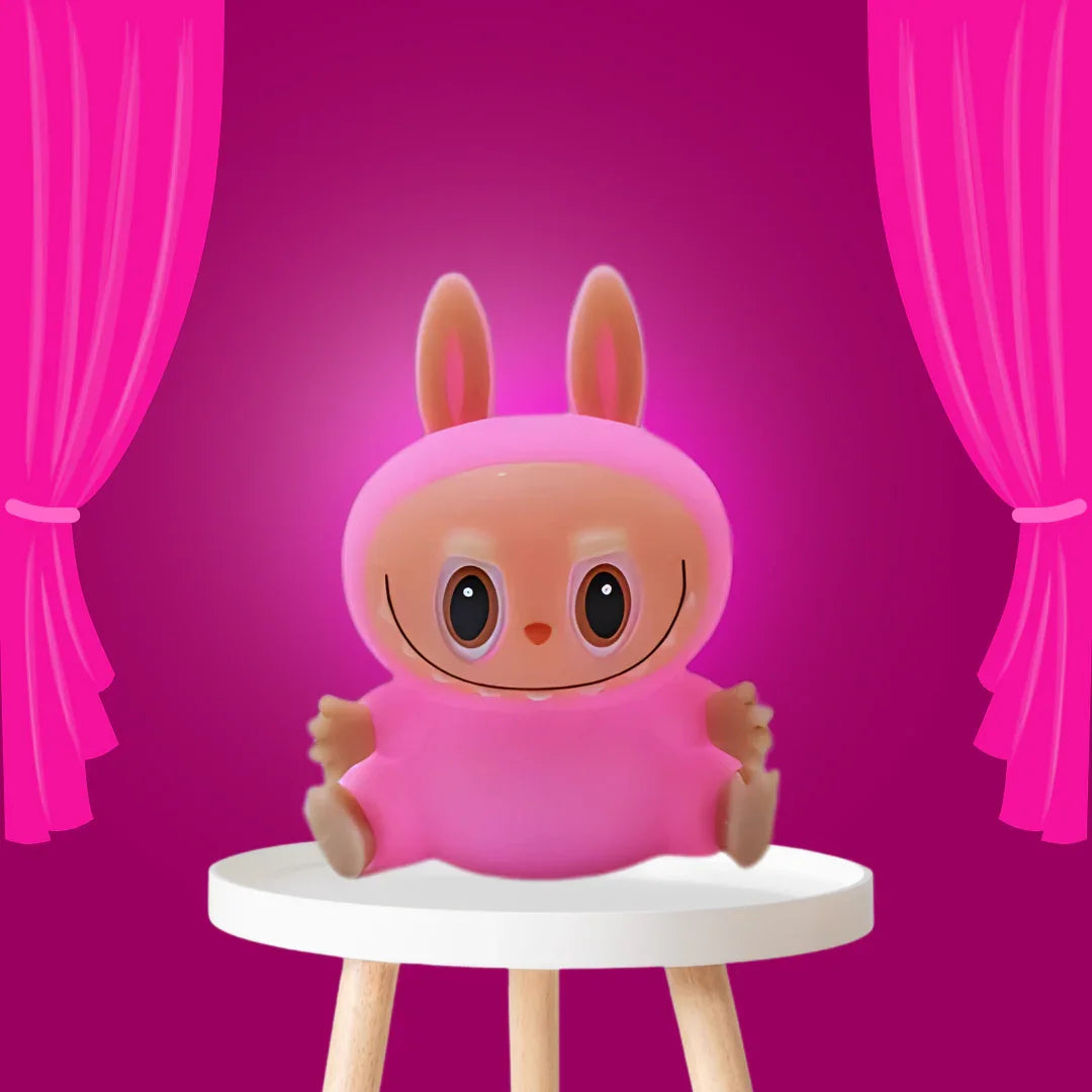 Süßes rosa Kaninchen-Spielzeug auf Hocker vor pinkem Hintergrund, Morivar Accessoire
