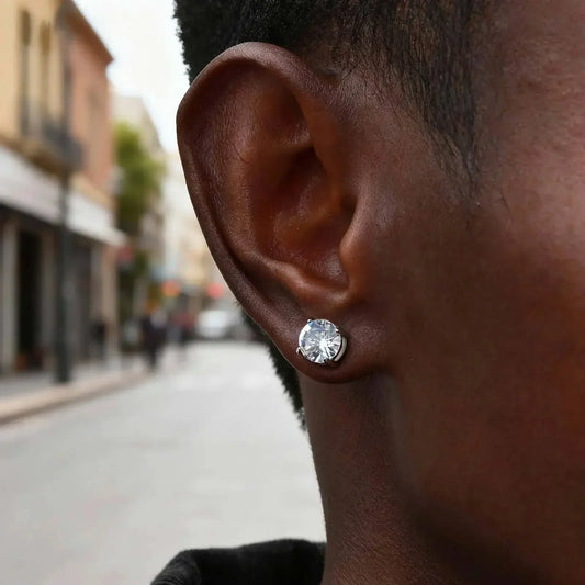 Nahaufnahme eines Ohrs mit silbernem Ohrstecker, Morivar Accessoire, Straße im Hintergrund.